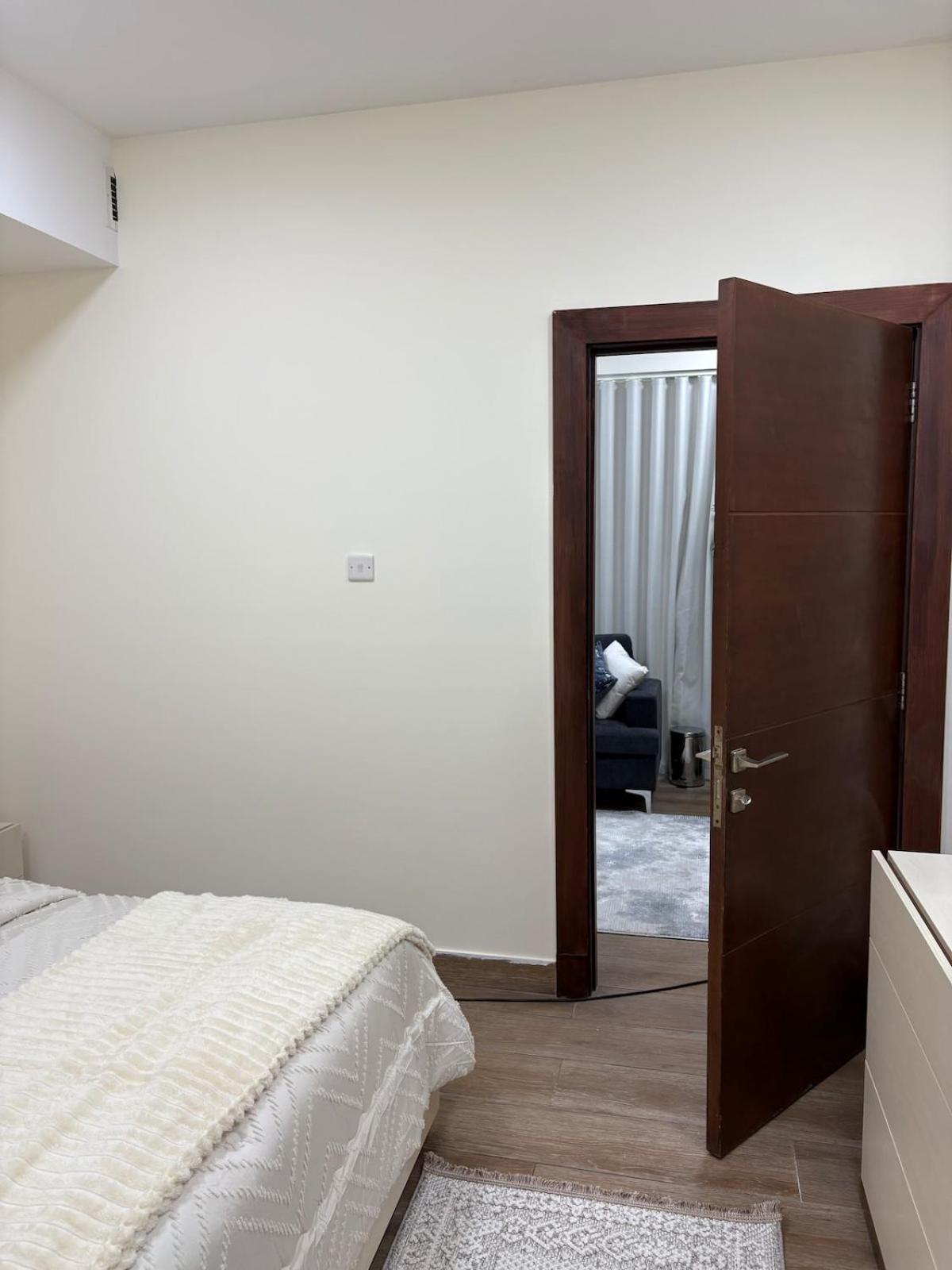 a bedroom with a bed and a open door at جناح الملكي غرفتين بمسبح خاص نظام التدفئة in Amwaj Island