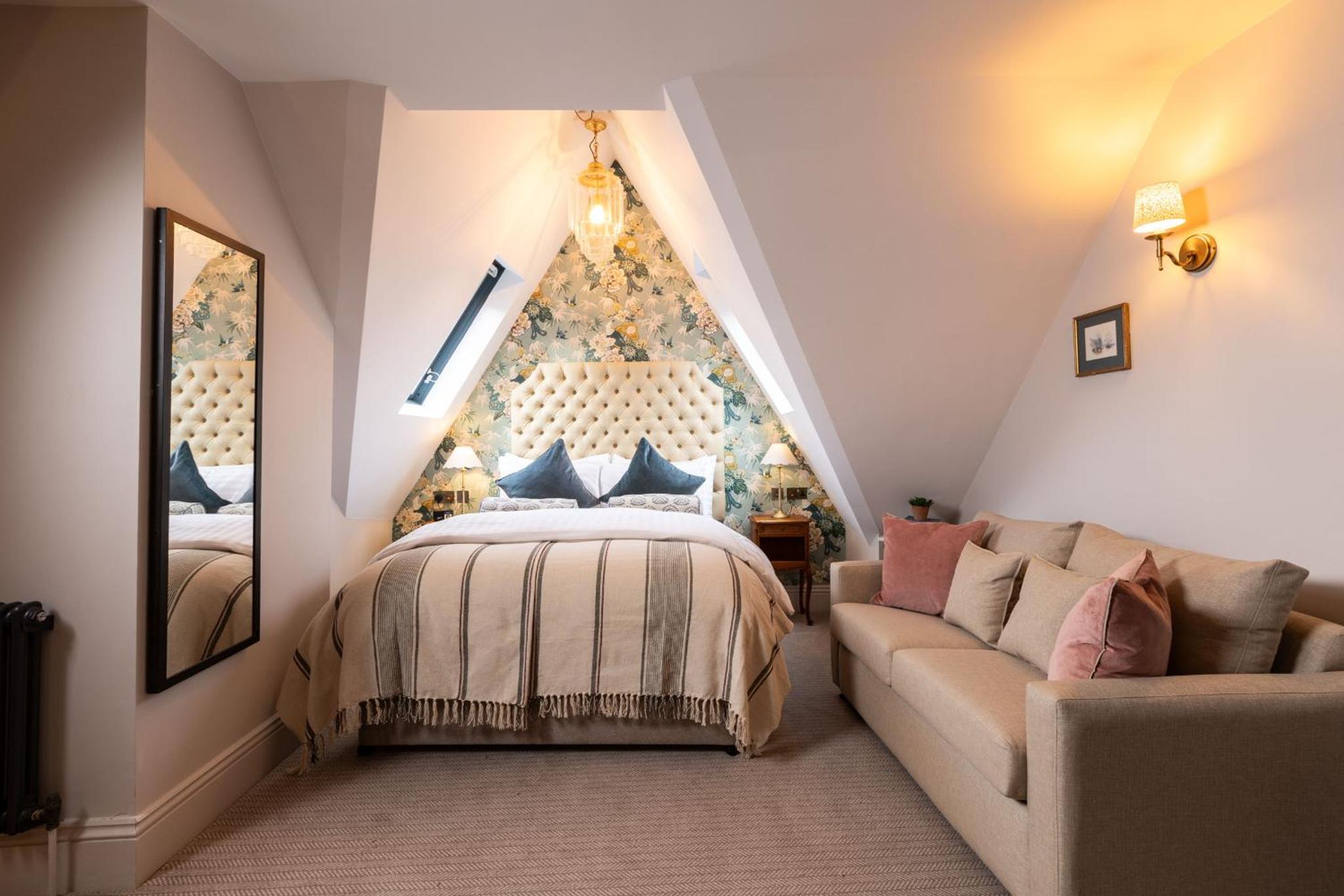 a bedroom with a bed and a couch at The Red Lion Hotel in London