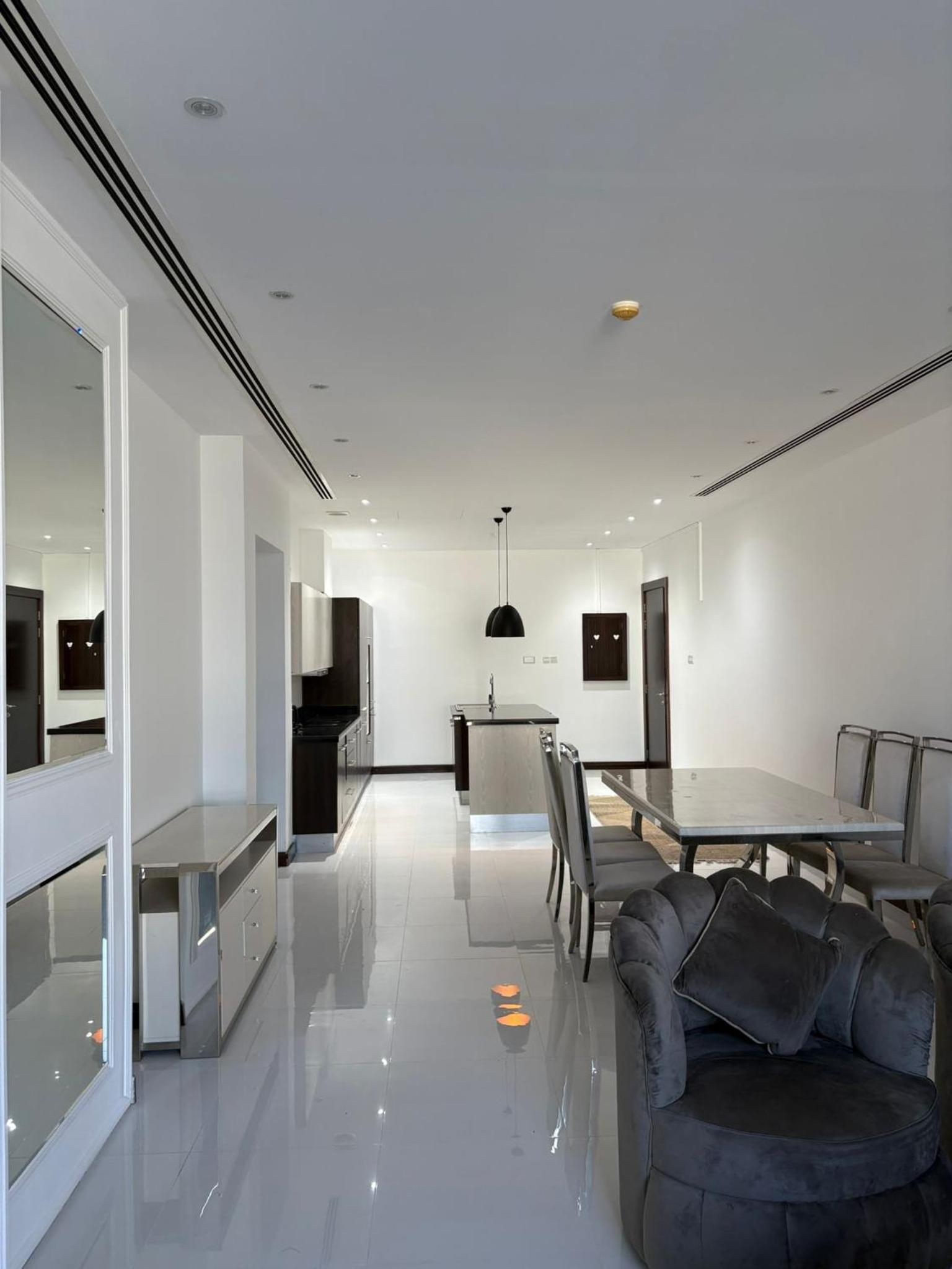 a dining room and living room with a table and chairs at شقة فخمة بإطلالة بحرية في امواج in Muharraq