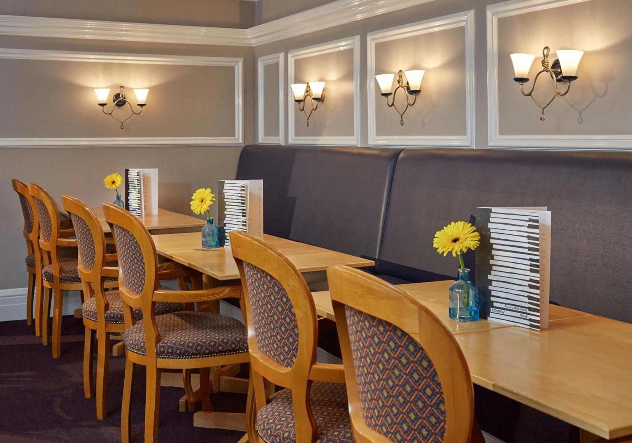 a dining room with a table and chairs and a keyboard at Lancaster Gate Hotel in London