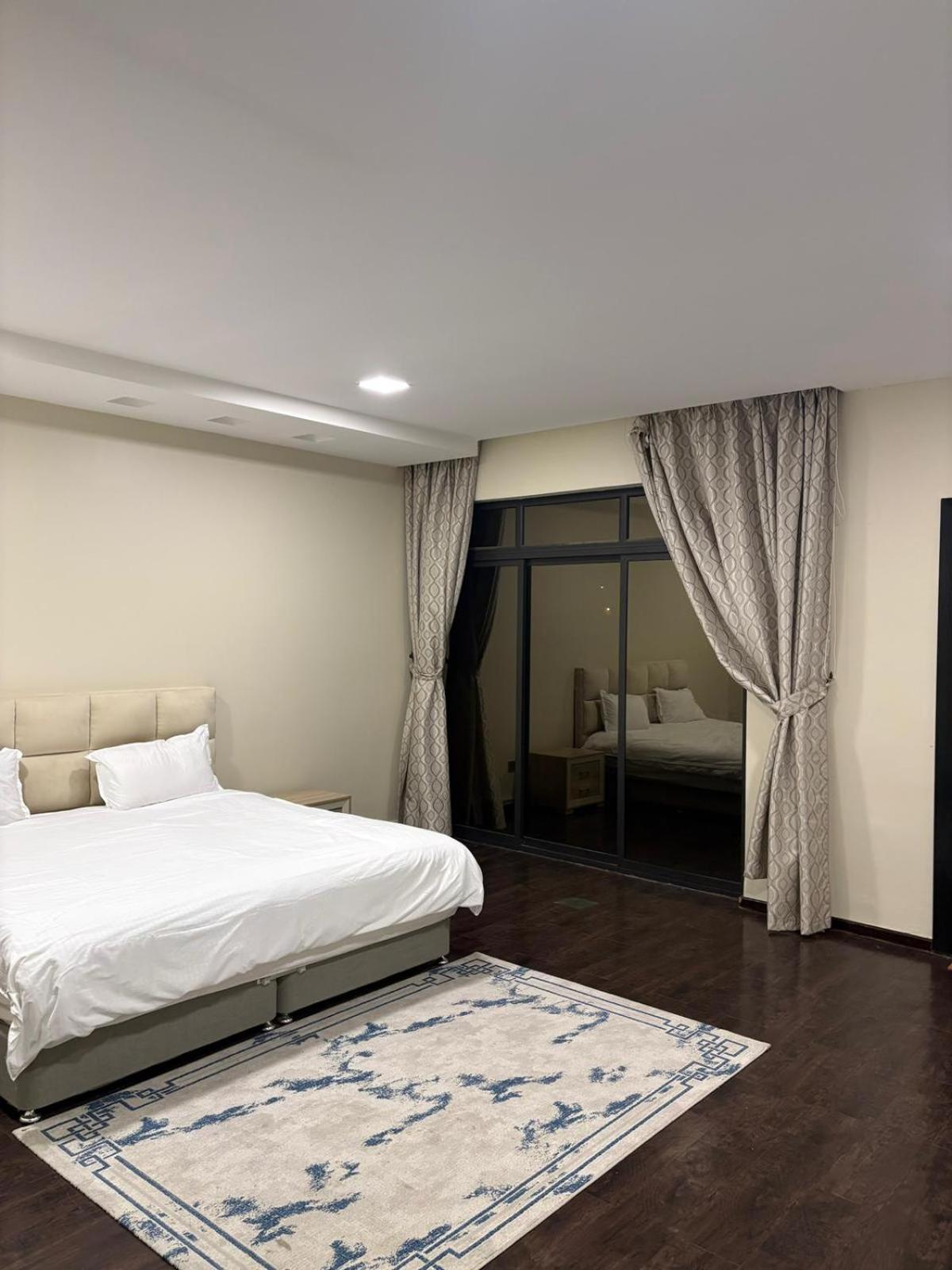 a bedroom with a white bed and a rug at شاليةسرايا البحر4 غرف نوم مسبح خاص وبحر in Amwaj Island