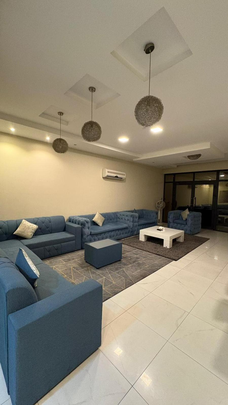 a living room with a blue couch and a table at شاليةسرايا البحر4 غرف نوم مسبح خاص وبحر in Amwaj Island