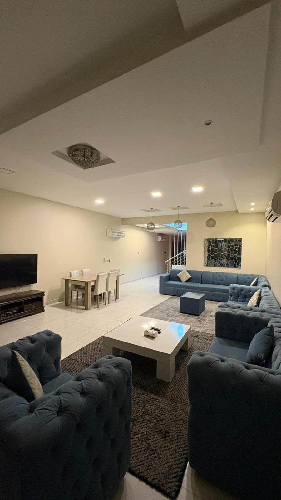 a living room with blue couches and a table at شاليةسرايا البحر4 غرف نوم مسبح خاص وبحر in Amwaj Island