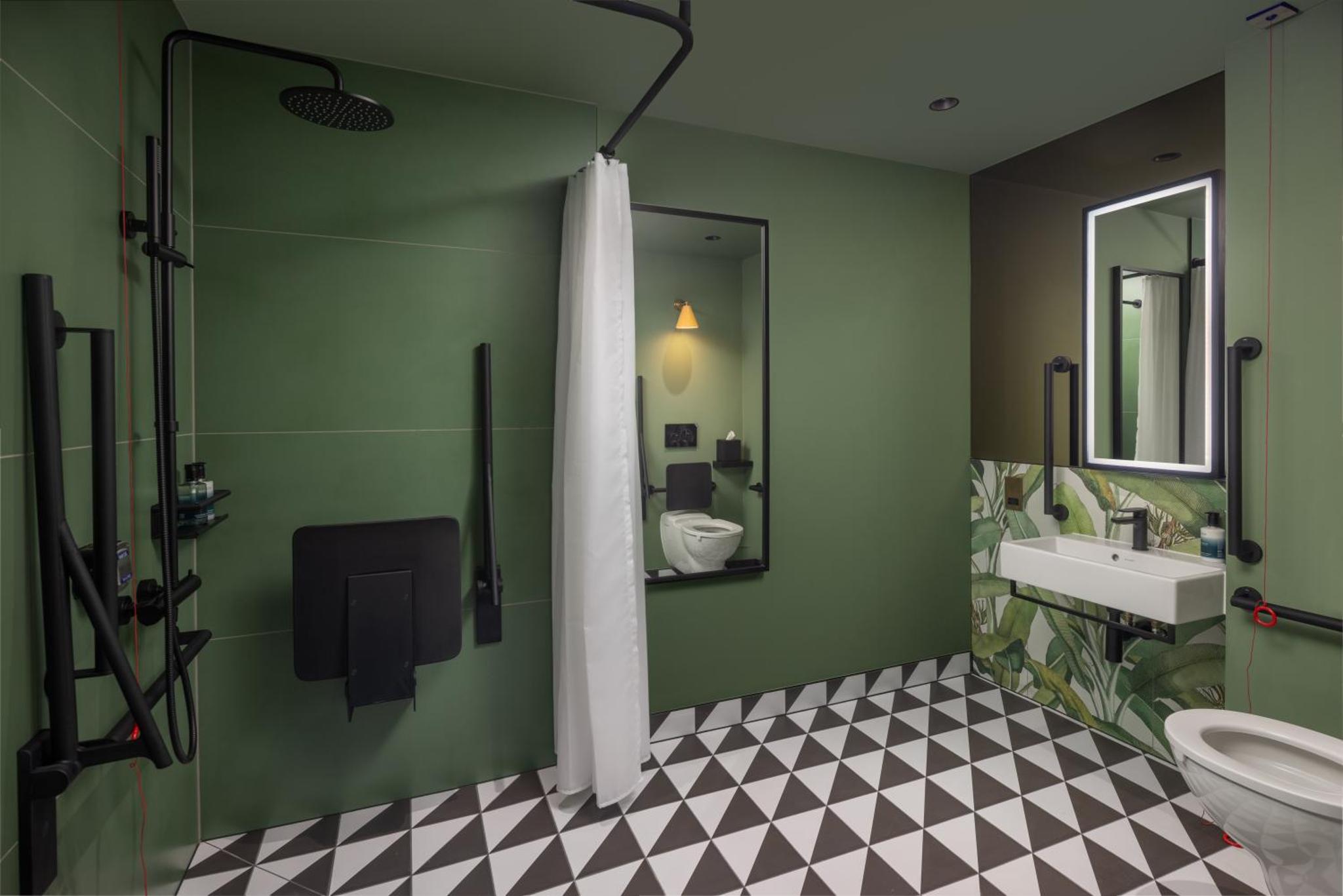 a green bathroom with a toilet and a sink at The Kensington Hideaway in London