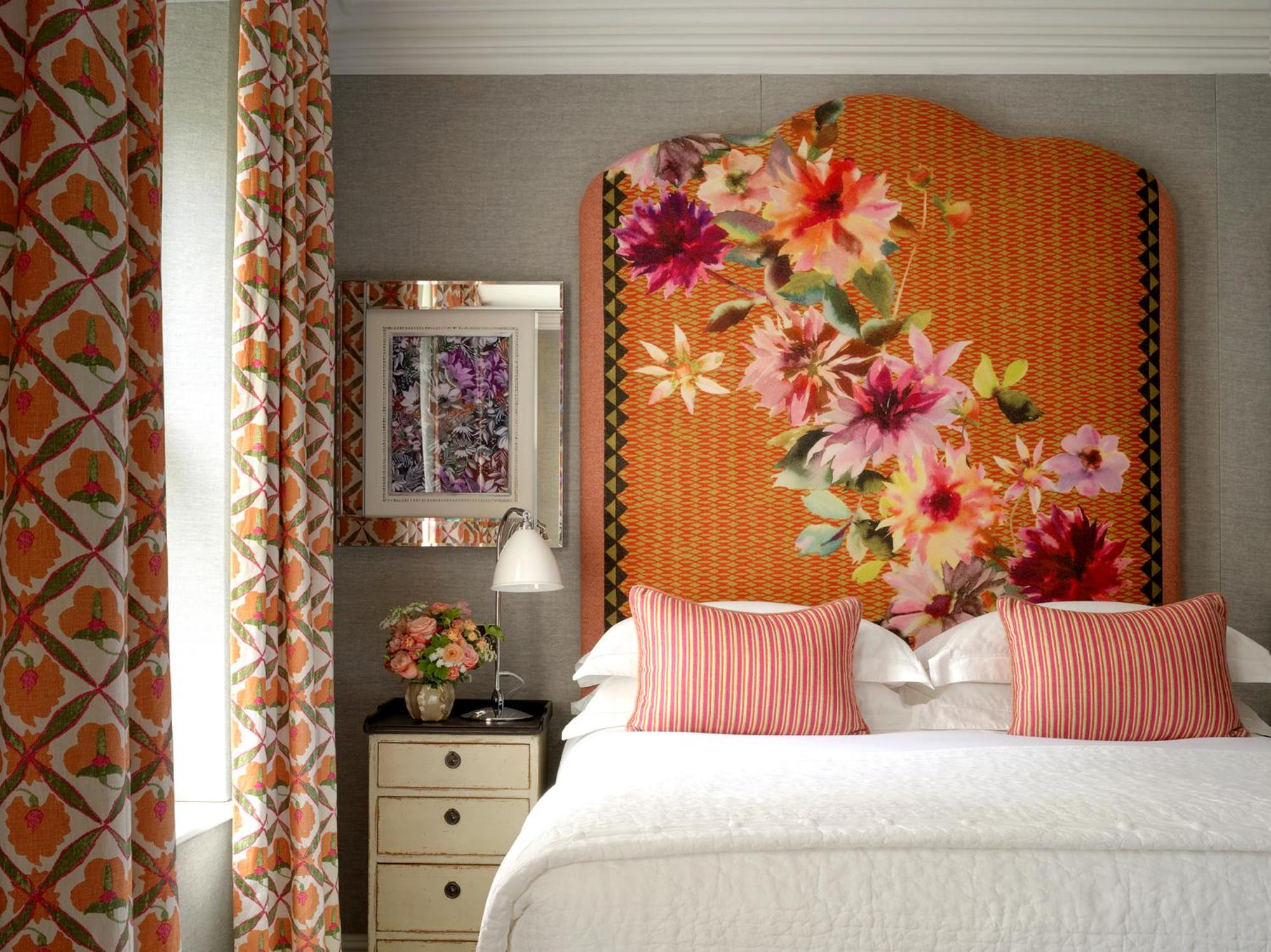 a bedroom with a large bed with an orange floral headboard at Knightsbridge Hotel, Firmdale Hotels in London +17 photos