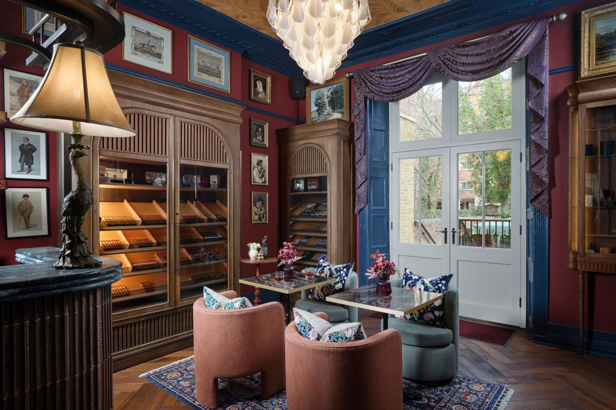a dining room with red walls and a chandelier at Bertrand's Townhouse in London