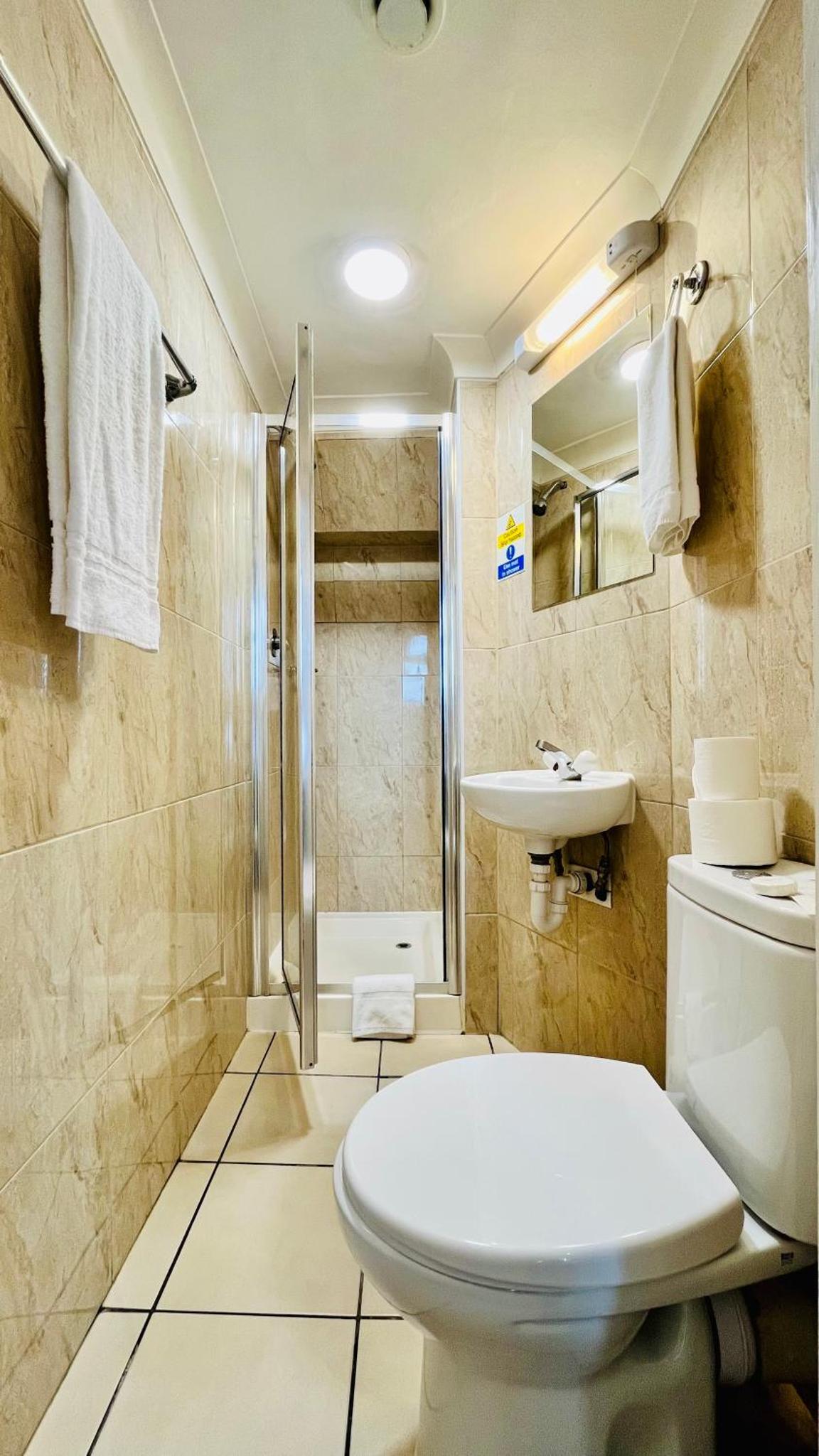 a bathroom with a toilet and a sink and a shower at West Cromwell Hotel in London