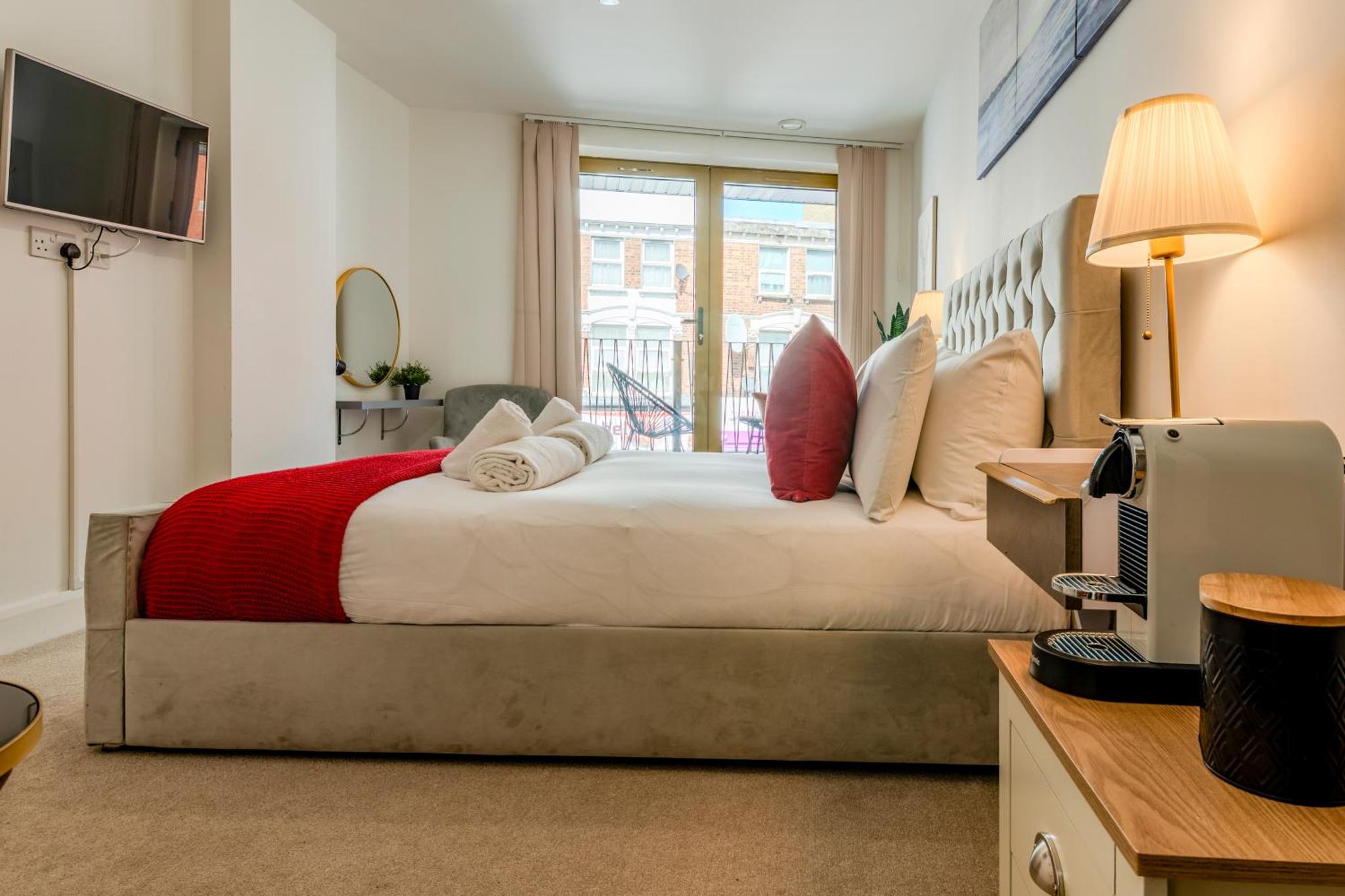 a bedroom with a bed and a desk with a computer at Luxe London Retreat by Aureva Residences in London