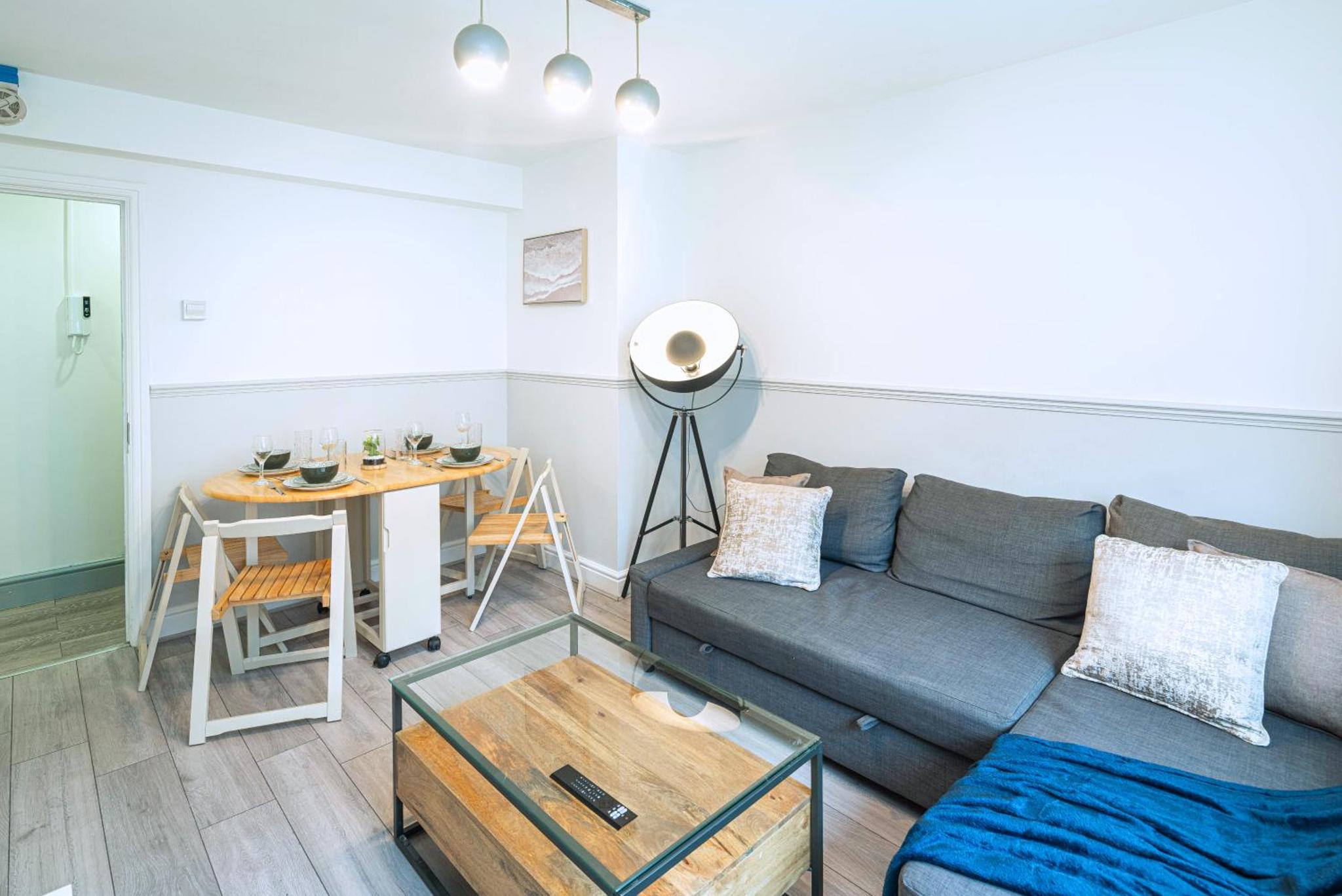 a living room with a couch and a table at Modern 3BR with Fast Links to Central London in London