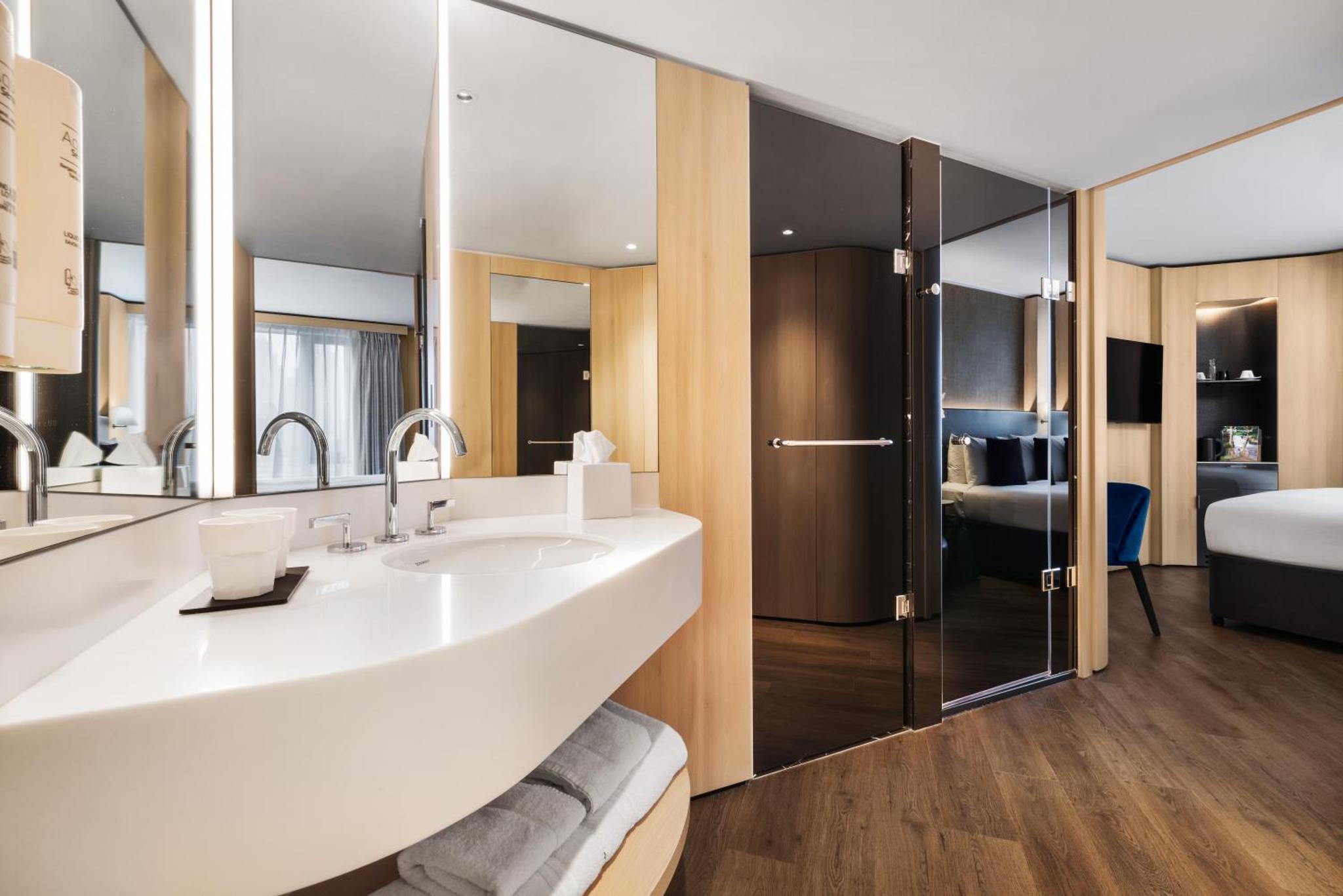a bathroom with a large white sink and a shower at Riu Plaza London The Westminster in London
