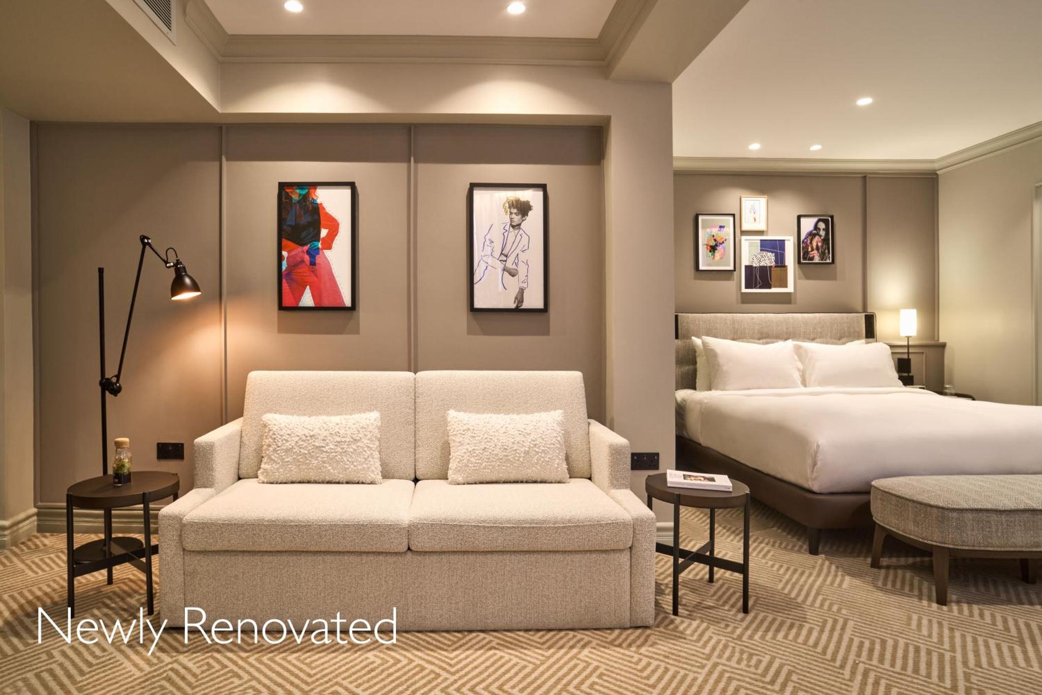 a bedroom with a bed and a couch and a bed and a bed at Radisson Blu Hotel, London Bond Street in London