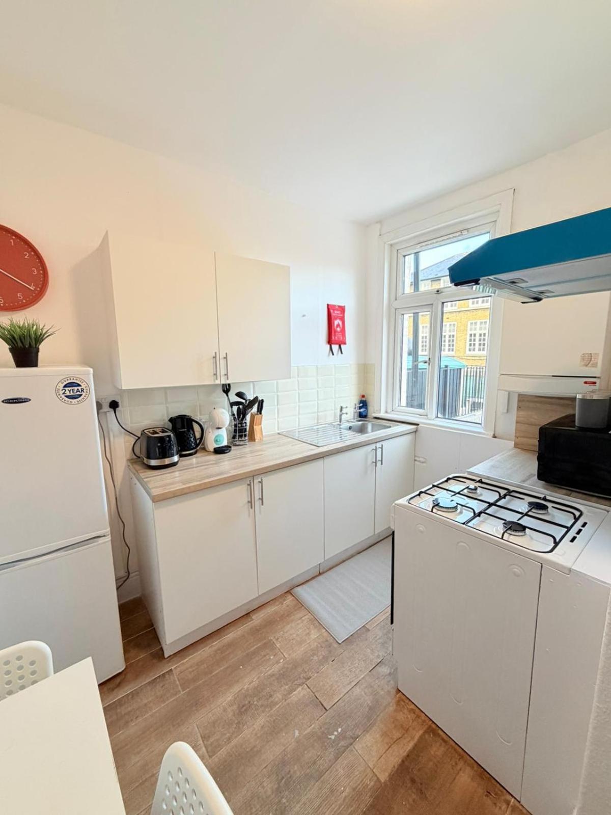 a kitchen with white cabinets and a stove top oven at London Tower Bridge Guest Rooms-72 in London +51 photos