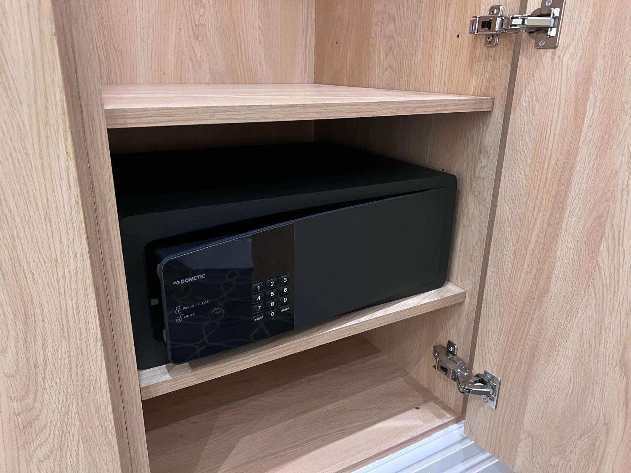 a microwave inside of a cupboard with a door at The Suites - St Pancras Hotel Group in London