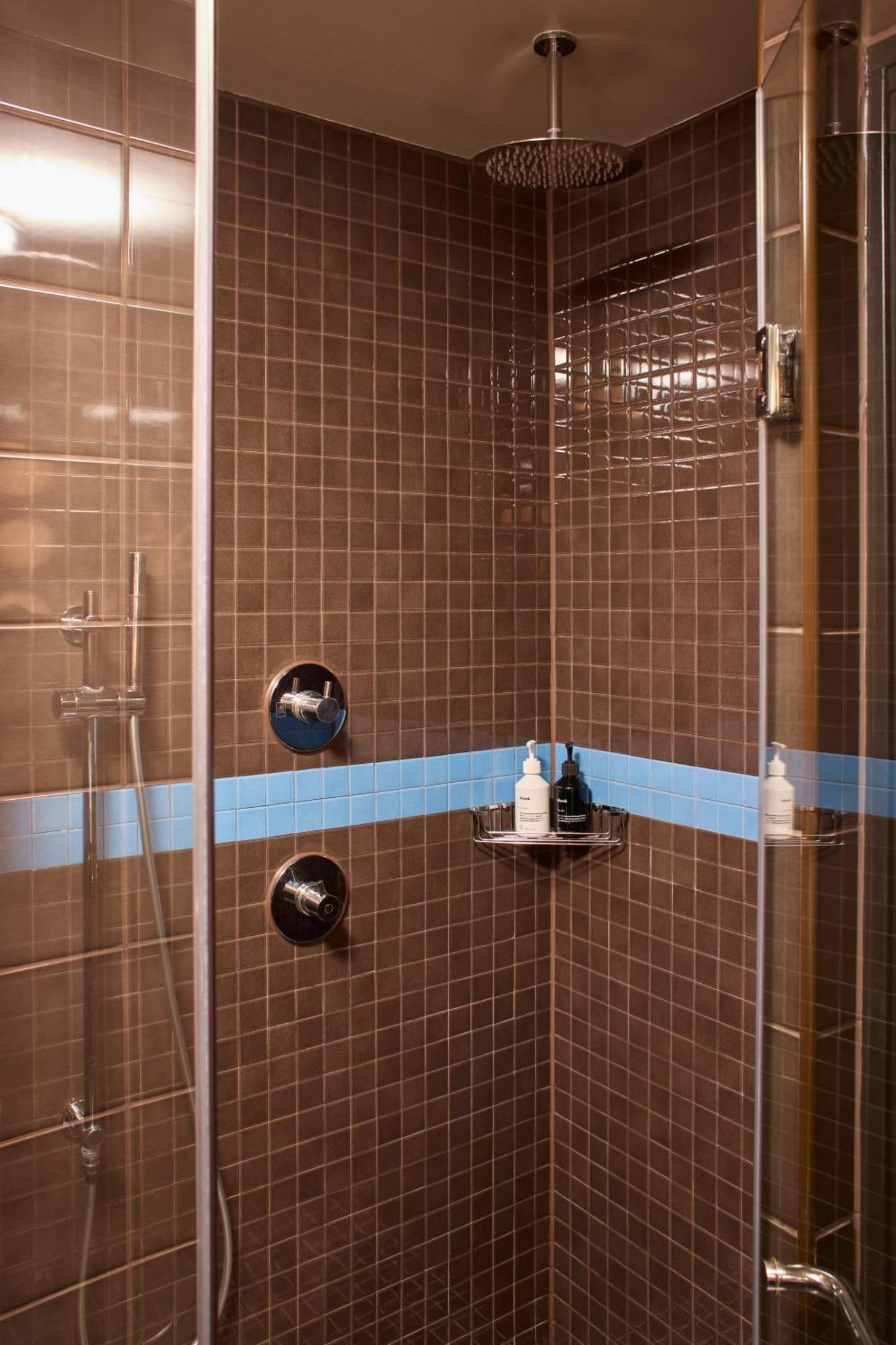 a bathroom with a shower with a glass door at The Hoxton, Shoreditch in London