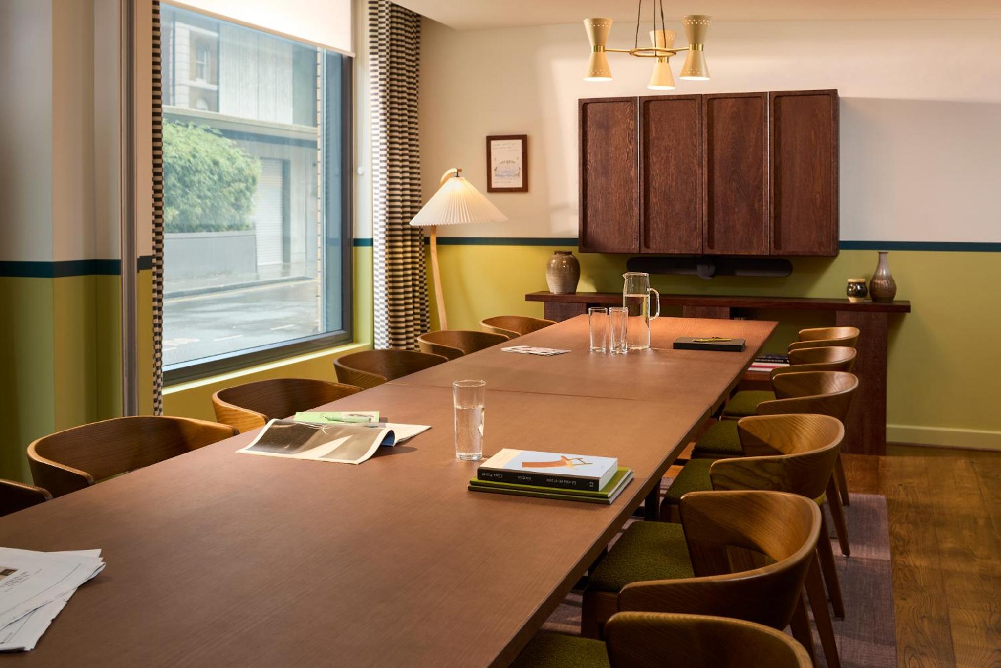 a conference room with a long table and chairs at The Hoxton, Shoreditch in London