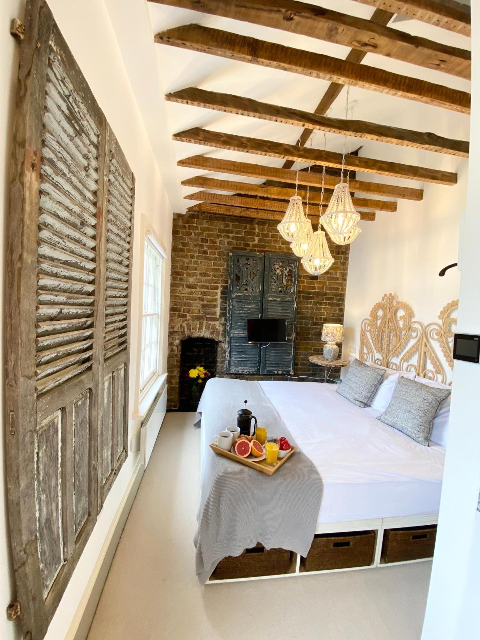 a bedroom with a bed with a tray of fruit on it at Stylish Studios in Pimlico & Victoria in London