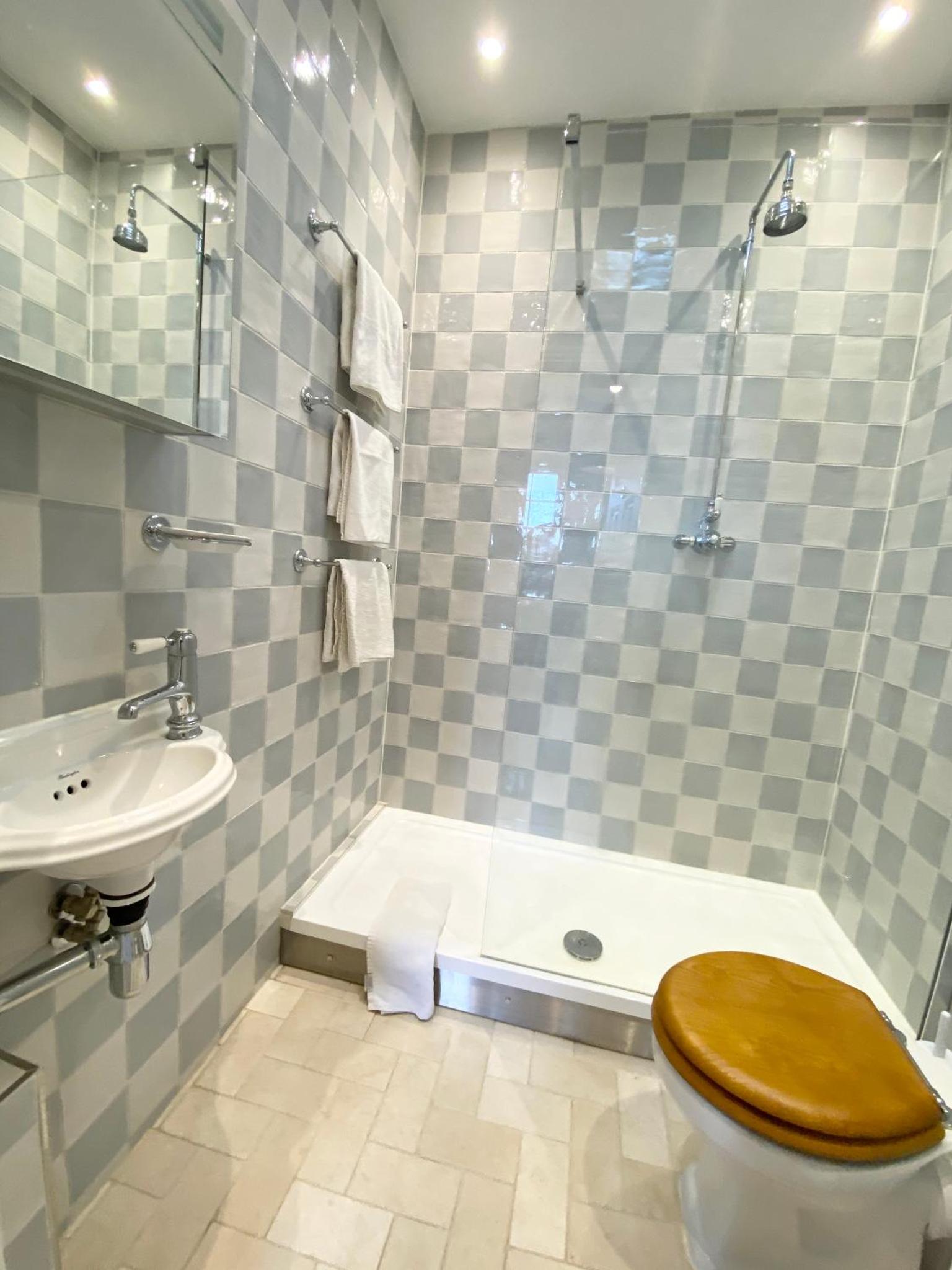 a bathroom with a toilet and a shower and a sink at Stylish Studios in Pimlico & Victoria in London