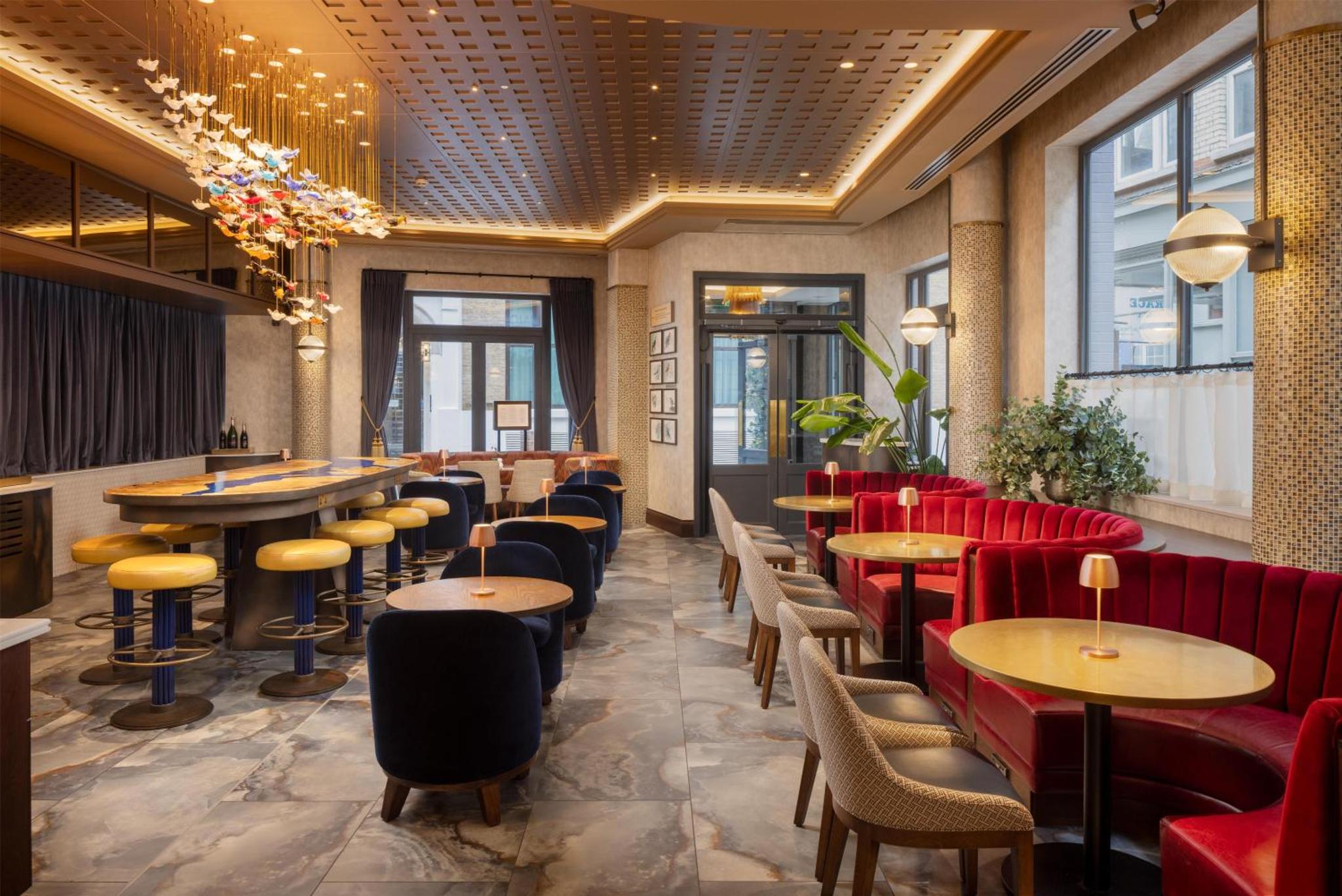 a restaurant with tables and chairs in a room at Lost Property St Pauls London, Curio Collection By Hilton in London