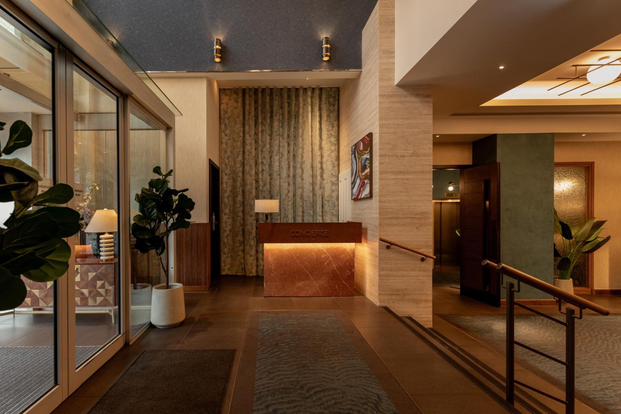 a lobby of a hotel with a hallway with plants at DoubleTree by Hilton London Victoria in London