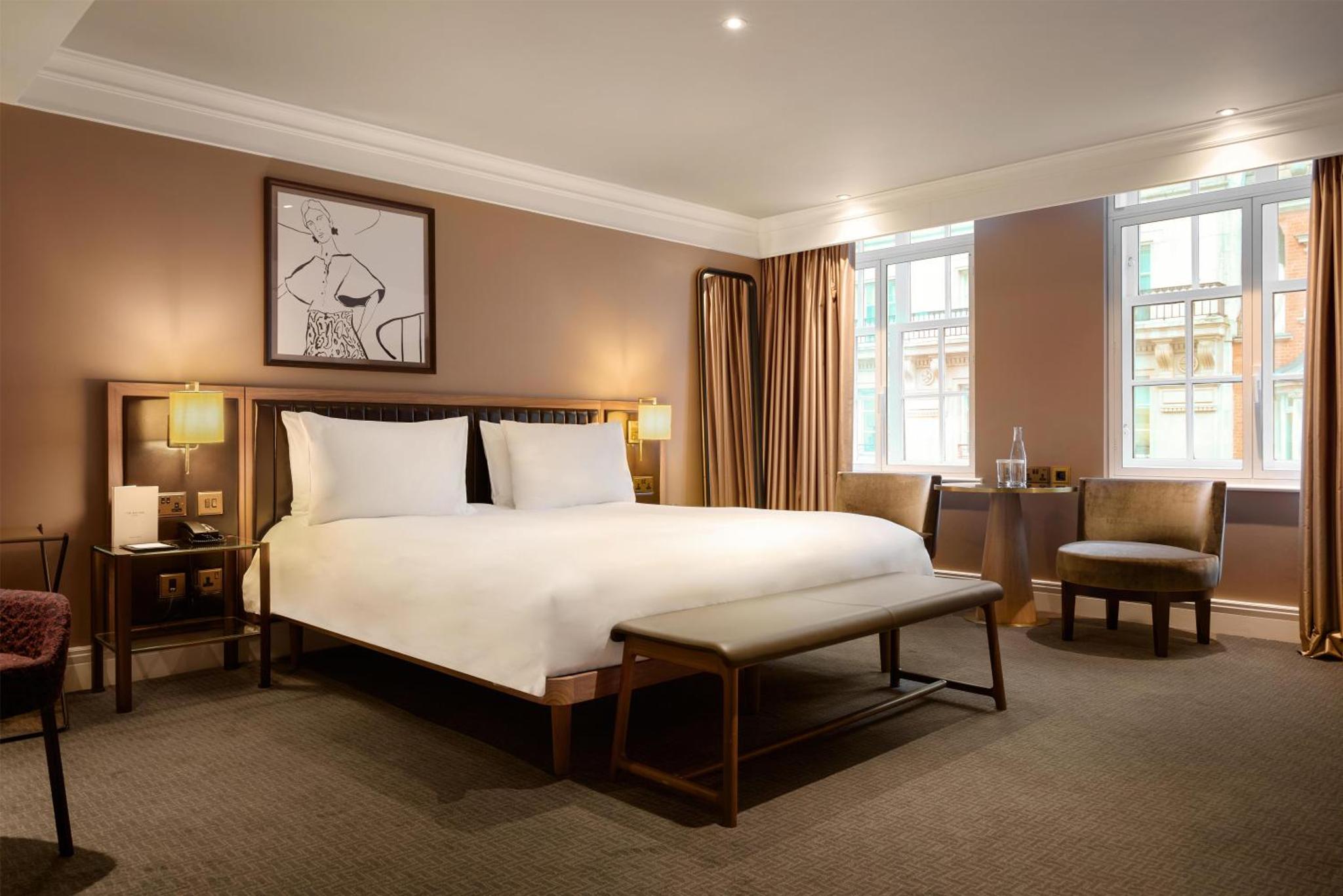 a hotel room with a bed and a desk and chairs at The May Fair, A Radisson Collection Hotel, Mayfair London in London