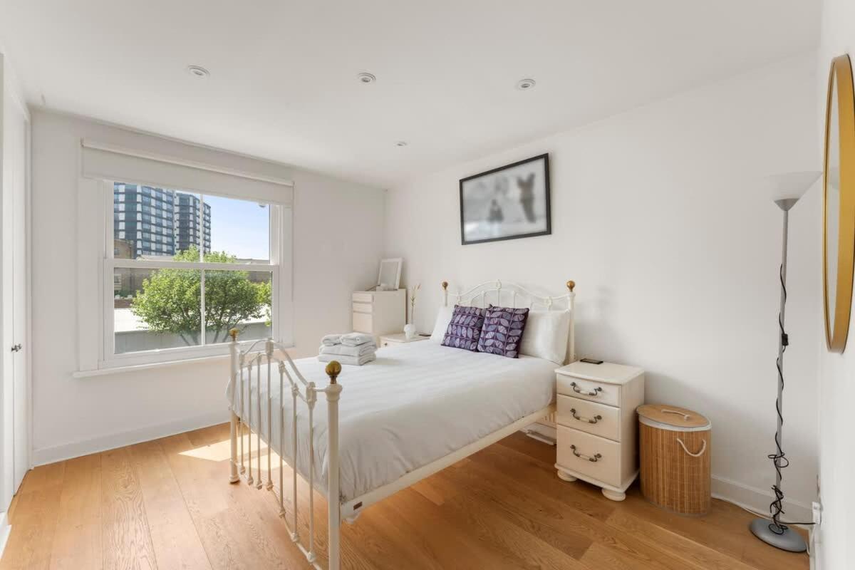 a white bedroom with a bed and a window at Spacious 1 Bed Maisonette in Camden by Amber Stays, Perfect for Long Term Stays, Sleeps 4 in London +23 photos