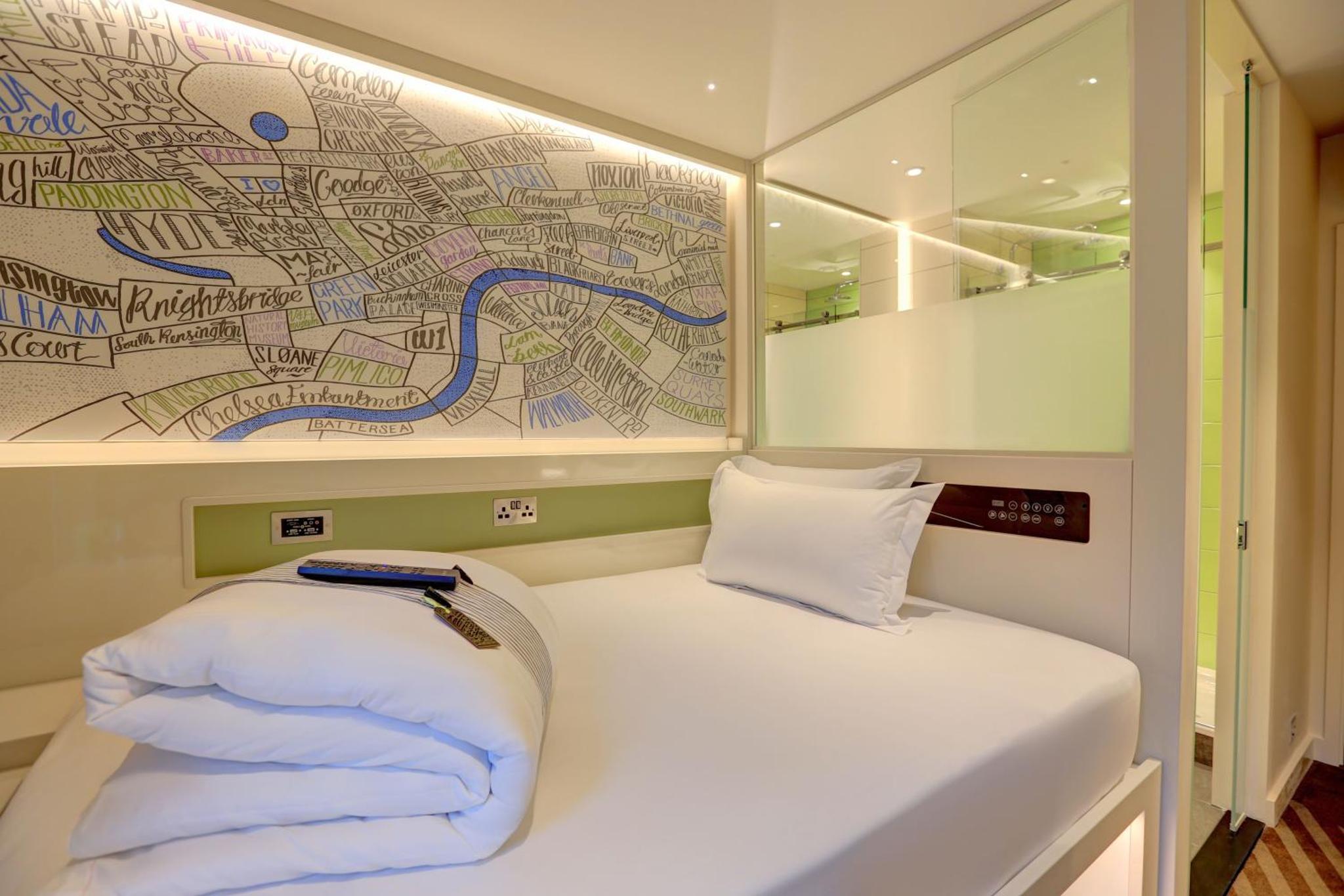 a small bed in a room with a map on the wall at hub London - Goodge Street in London