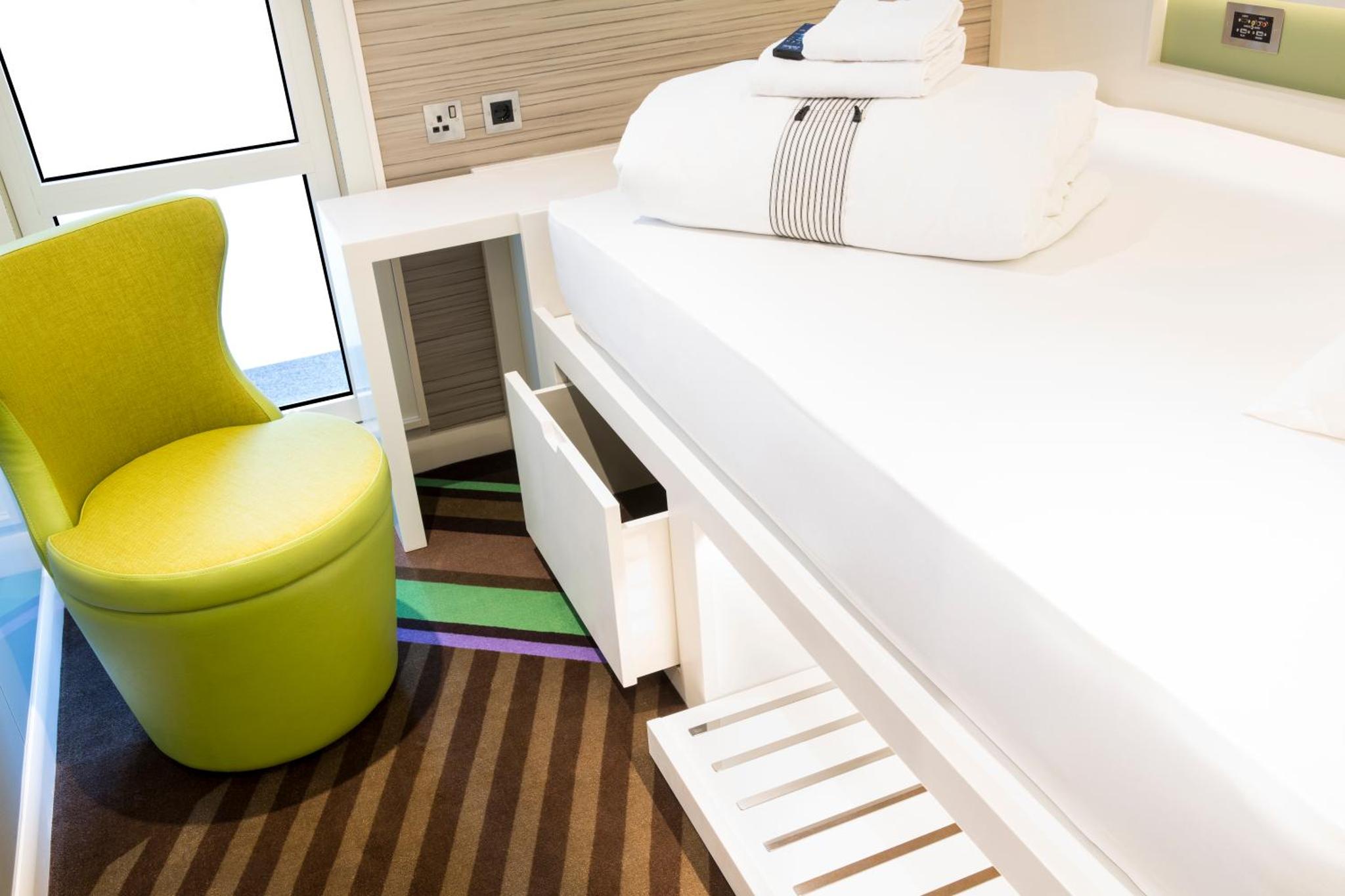 a bedroom with a yellow chair and a bed at hub London - Goodge Street in London +18 photos