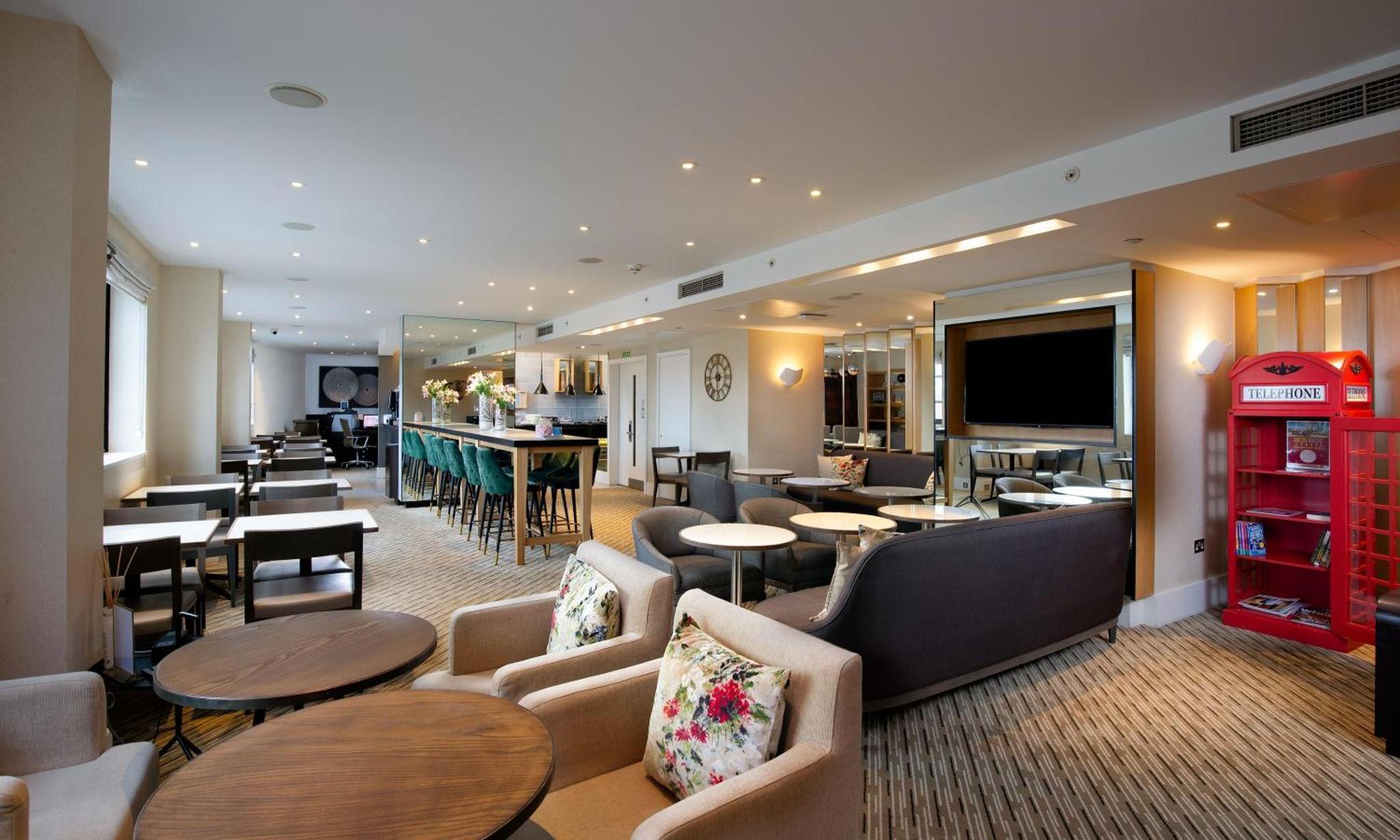 a restaurant with tables and chairs and a soda machine at Hilton London Tower Bridge in London