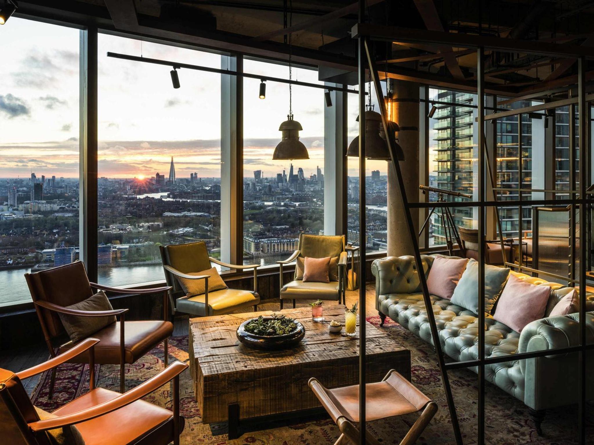 a living room with a view of the city at Novotel London Canary Wharf in London
