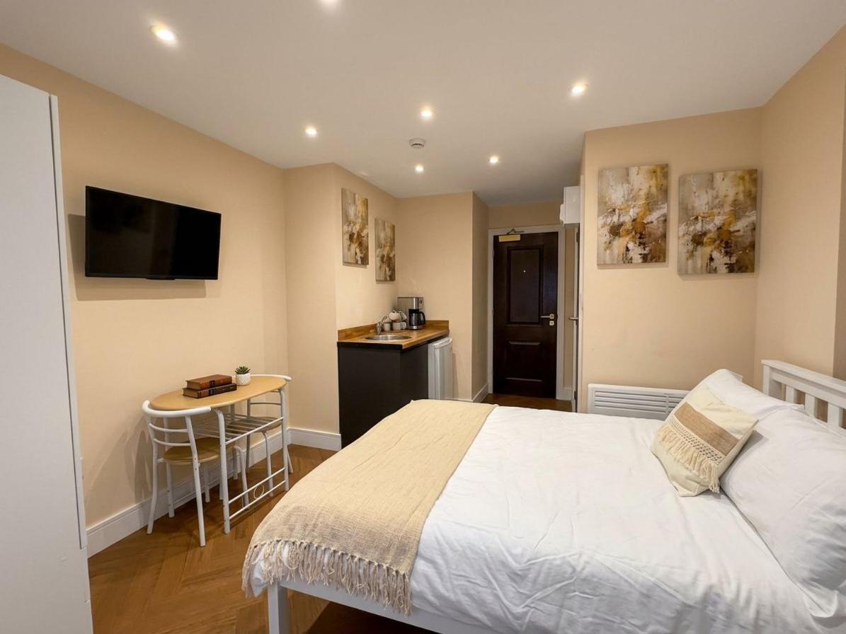 a bedroom with a bed and a small kitchen at 30B The Lux Studios Near Arsenal and Central London in London