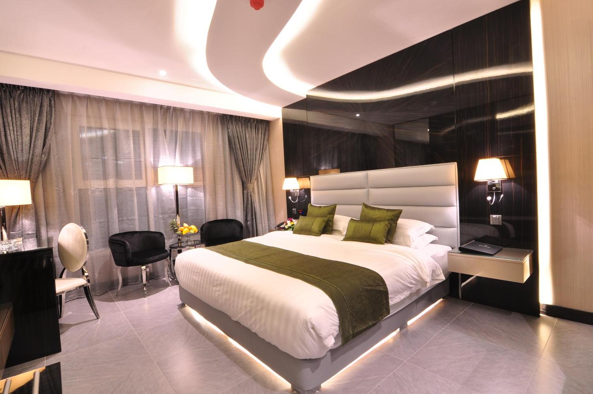 a bedroom with a large bed and a desk at Frsan Palace Hotel in Manama