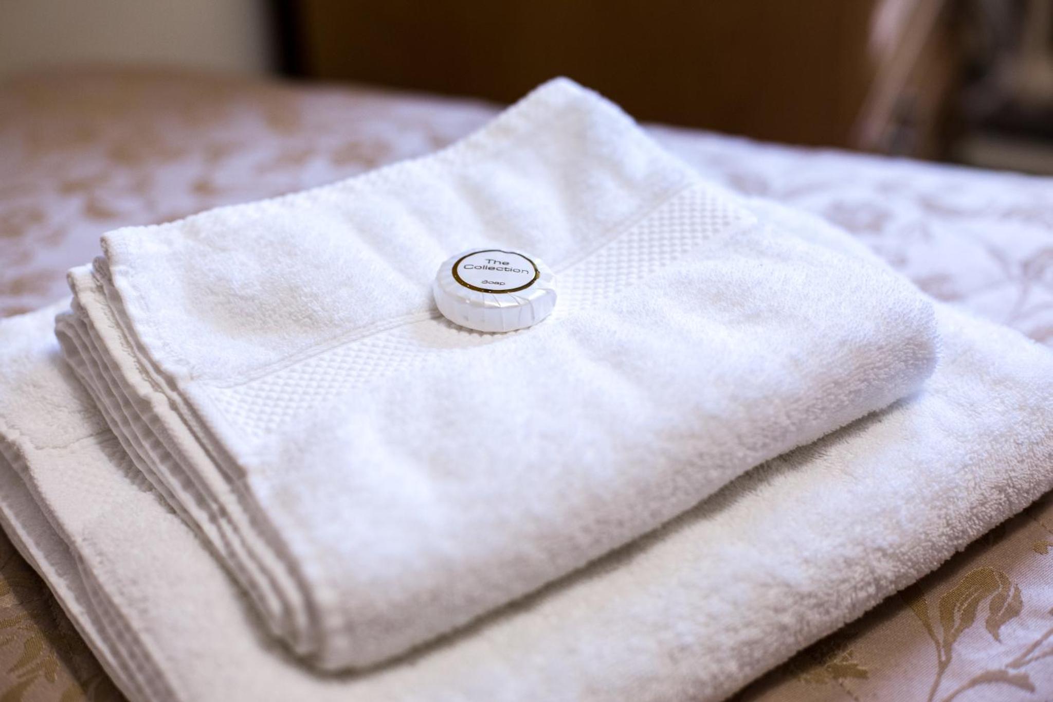 a white towel sitting on top of a bed at Vincent House London Residence in London