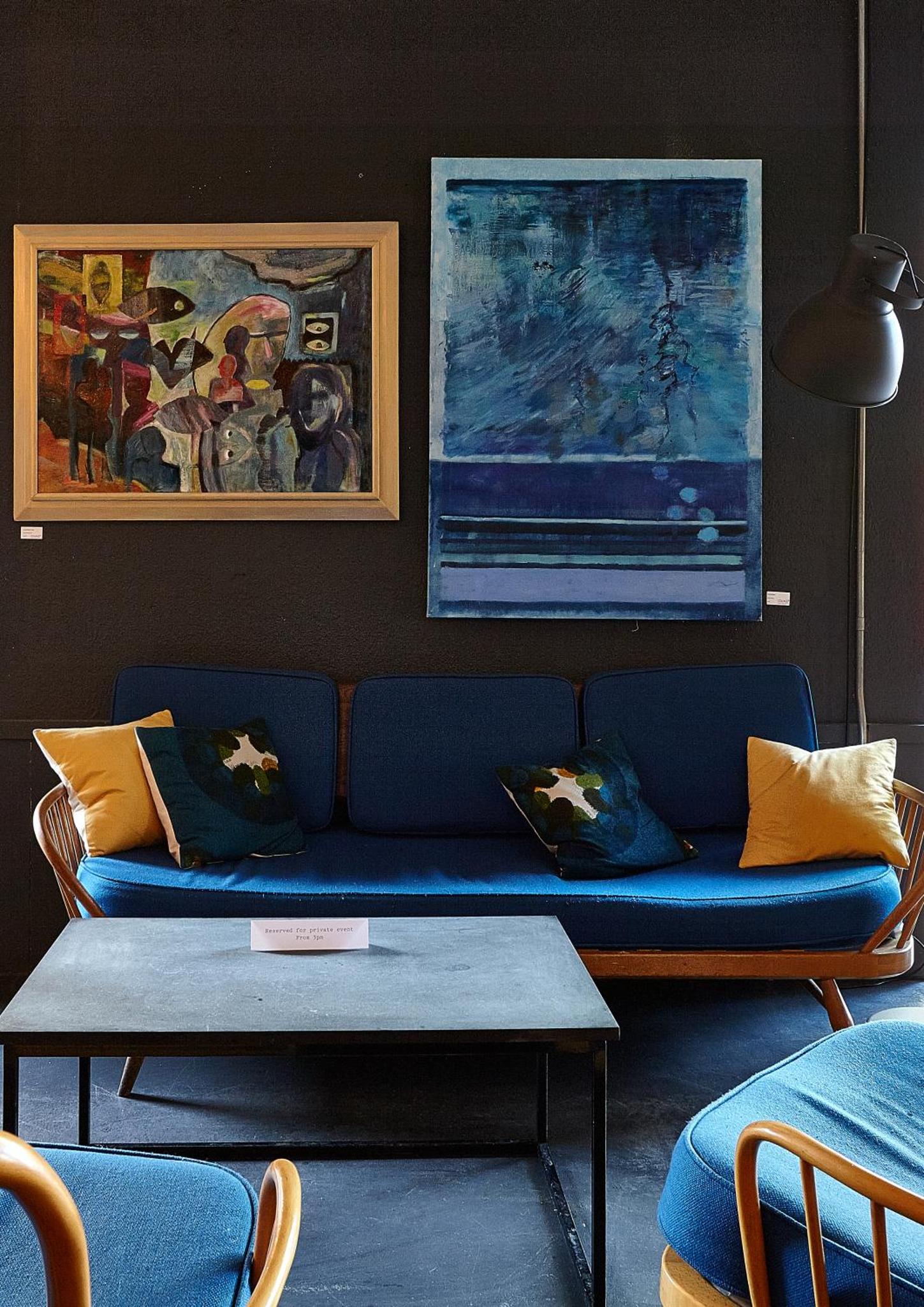 a blue couch in a living room with a table at Green Rooms in London