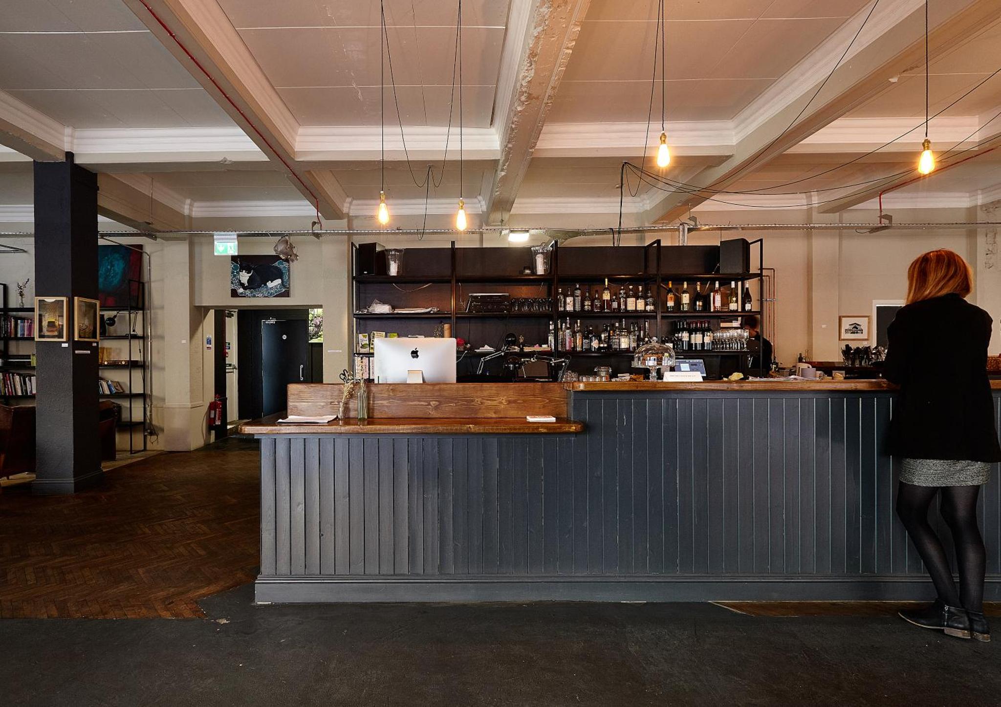 a woman standing at the counter of a bar at Green Rooms in London