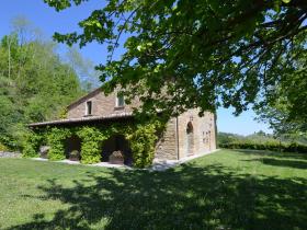 Stone house in the green rolling hills of the Apennines with garden