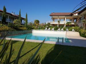 a swimming pool in a yard next to a house at De Luxe Apartments Eden in Sirmione