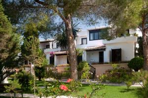 a large white house with trees in the yard at Paraíso de los Pinos in Sant Francesc Xavier
