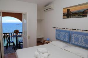 a bedroom with a bed and a view of the ocean at Antica Pensione Pinna in Castelsardo