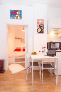 a white kitchen with a table and a bed at Aristotelous street small apartment in Thessaloniki
