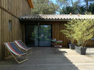 un grupo de sillas y mesas en un patio en Le Domaine d'Azae, en Gujan-Mestras