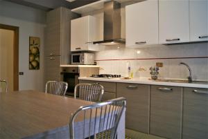 BolognettaにあるMastro Toto' - Rooms & Apartmentの白いキャビネット、テーブルと椅子付きのキッチンが備わります。