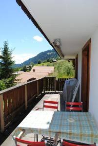 un patio con tavolo e sedie sul balcone. di Ferienwohnung Käch a Habkern