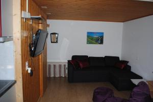 a living room with a black couch and a flat screen tv at Ferienwohnung Käch in Habkern