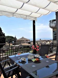 a table on a balcony with a view of the city at La Petite Maison in Taormina