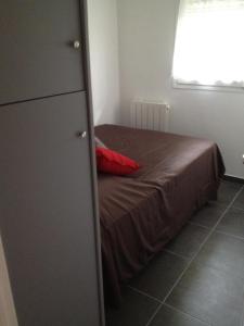 a bedroom with a bed with a red pillow at K&A Apartment in Aulnay-sous-Bois