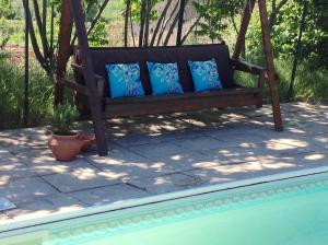 a wooden bench with blue pillows sitting on a patio at Domaine Charente - Cottage Charente in Mazières +29 photos
