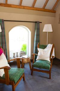 a living room with two chairs and a window at Bed and Breakfast Klein Groenbergen in Leersum