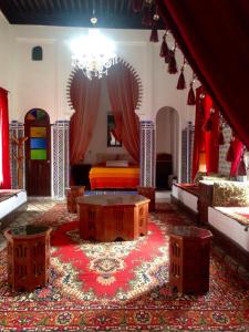 a living room with a table and red curtains at Hotel Riad Dalia Tetouan in Tetouan