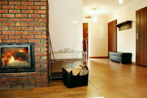 een woonkamer met een bakstenen muur en een open haard bij Domek Zieleniec in Duszniki Zdrój