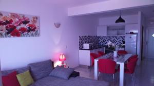 a living room with a couch and a table with red chairs at Apartments Zunic in Trogir